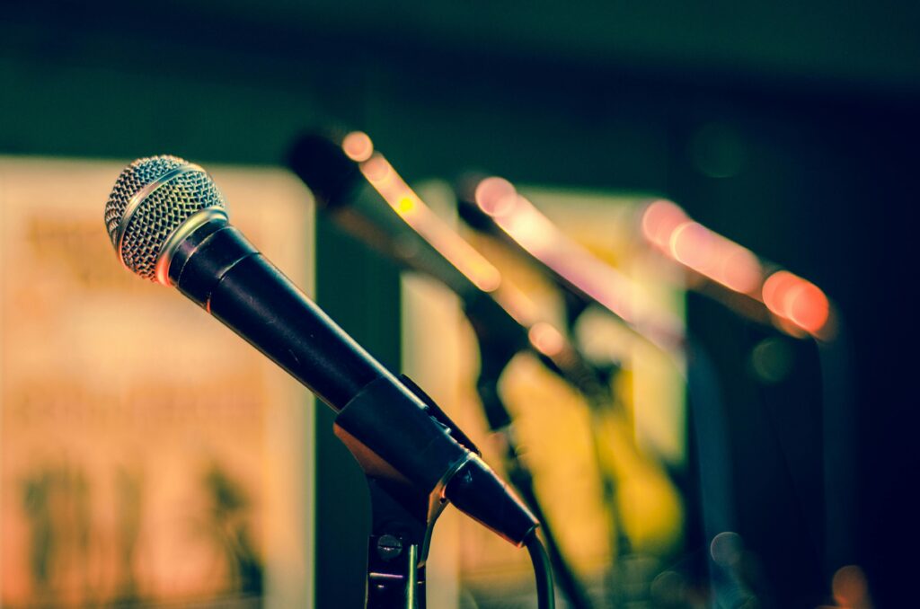Microphones in focus with colorful blurred background, ideal for music events.